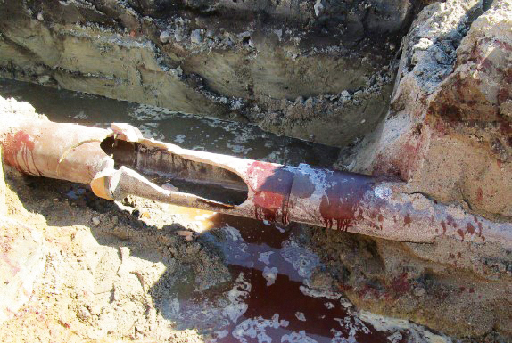 Beschädigtes Leitungsrohr: Der Leitungsgraben für eine neue Trinkwasserleitung wurde mit einem Kettenbagger hergestellt. Beim Aushub des Erdbodens wurde die vorhandene Abwasserleitung, ein Steinzeug-Rohr DN 200, beschädigt.