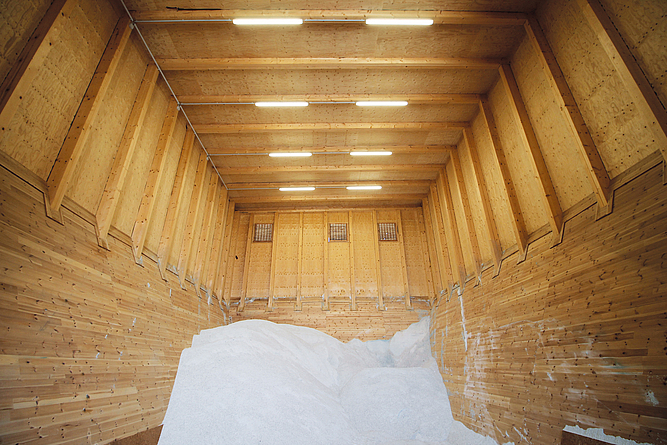 Halle komplett aus Holz, in der sich ein Salzhaufen befindet.