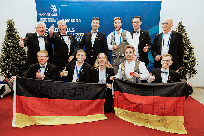Teilnehmerinnen und Teilnehmer, Bundestrainer und Vorstand von WorldSkills Germany jubeln über die gewonnenen Gold-, Silber- und Exzellenzmedaille.
