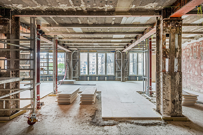 Nach dem Höhenausgleich durch die gebundene Schüttung wurden die Gipsfaser-Estrich-Elemente im schleppenden Verband verlegt. Baustelle in einem Gebäude, in dem Decken- und Fußbodenarbeiten durchgeführt werden. Ein Teil des Fußbodens wurde mit Platten ausgelegt.