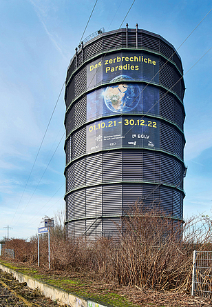 Sanierter Gasometer mit Riesenplakat zur aktuellen Ausstellung.