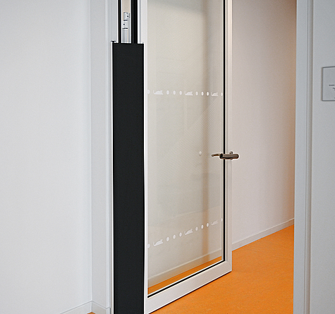 Blick auf eine geöffnete Glastür im Neubau: Sie ist am Türrahmen mit einem Fingerklemmschutz versehen. 