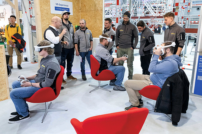 Besucher der DACH+HOLZ testen VR-Brille am Stand der BG BAU.