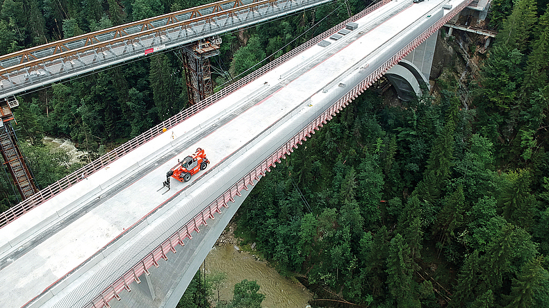 Nur die denkmalgeschützten Melan-Bögen blieben von der alten Konstruktion erhalten. Blick von oben auf eine Brücke für den Autoverkehr, die über ein tiefes Tal führt.