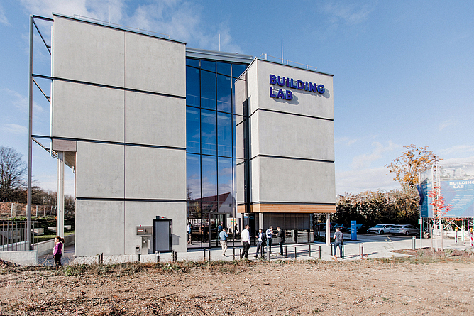 Modernes, mehrstöckiges Gebäude mit großer Glasfront. An der Seite ist der Schriftzug "Building Lab" angebracht.