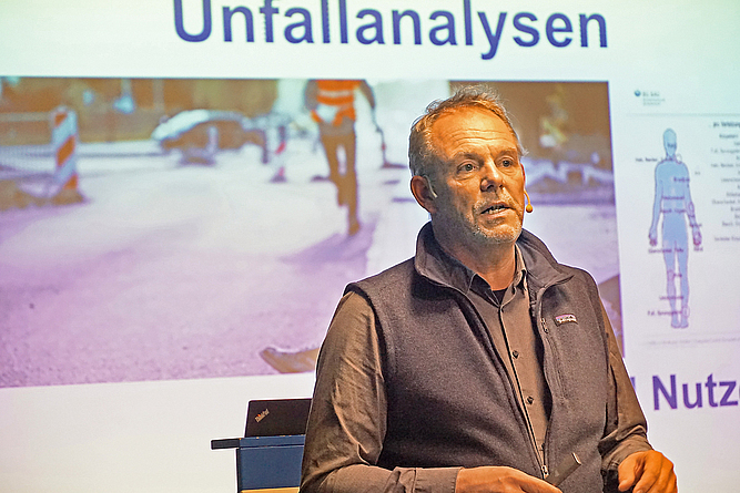  Marco Einhaus steht bei seinem Vortrag vor einer Folie.