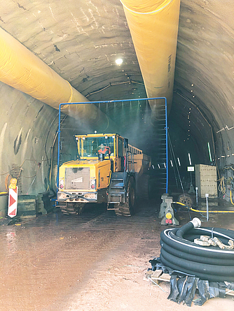 Blick in den Brandbergtunnel: Eine Baumaschine passiert die Fahrzeugschleuse am Tunneleingang.