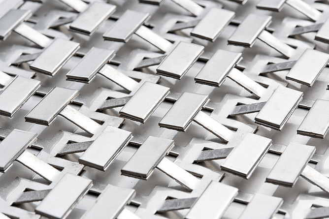 Materialstück mit plättchenförmigen Einzelteilen, die an kleinen Stegen herausragen.