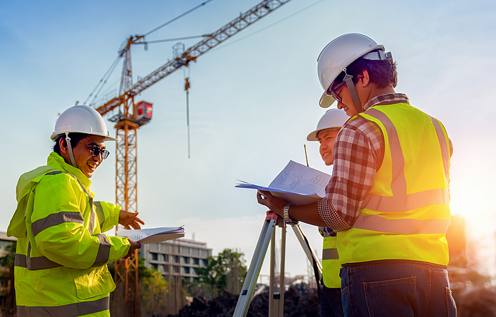 Bauingenieure sind in einem Gespräch mit einem Architekten auf einer Baustelle.