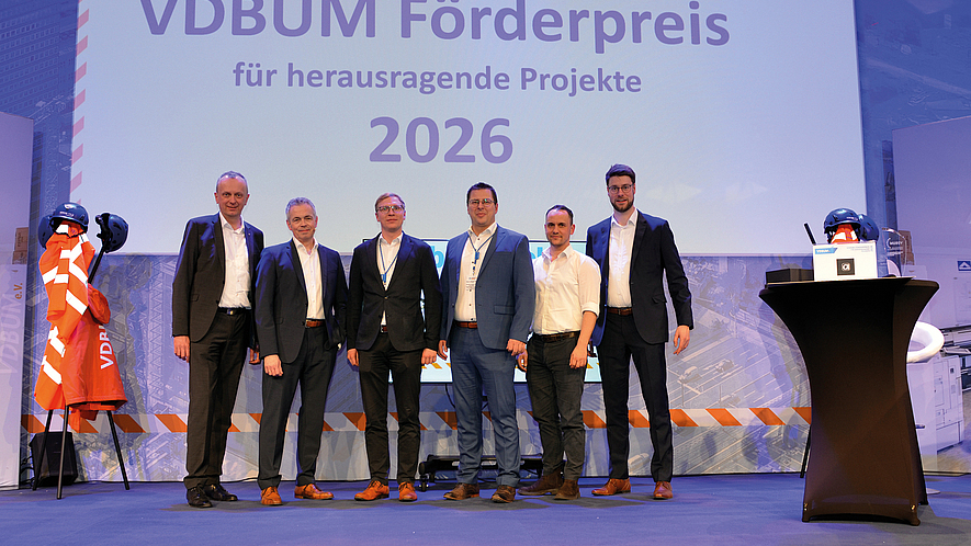Die Gewinner des VDBUM-Förderpreises stehen auf einer Bühne vor einer Projektionswand mit der Jahreszahl „2026“.