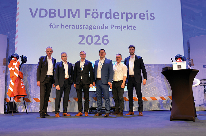 Die Gewinner des VDBUM-Förderpreises stehen auf einer Bühne vor einer Projektionswand mit der Jahreszahl „2026“.