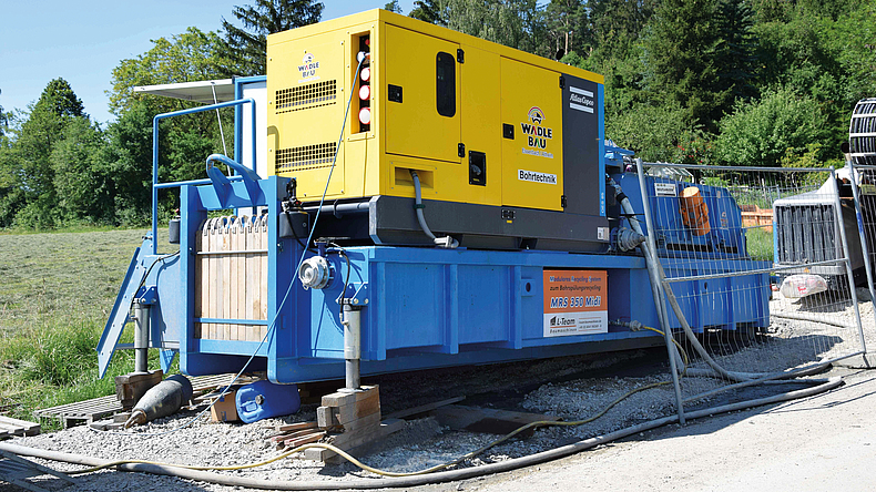 Eine große mobile Separationsplattform steht auf einem Weg vor einem Feld.