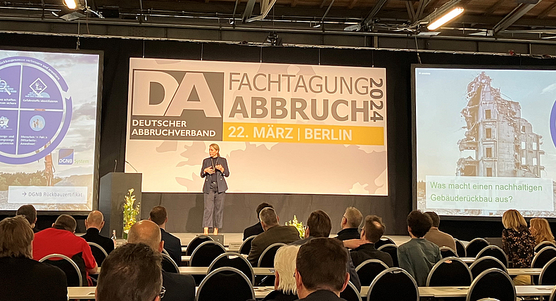 Vortrag von Christine Lemaitre Ein Frau steht auf dem Podium und referiert.