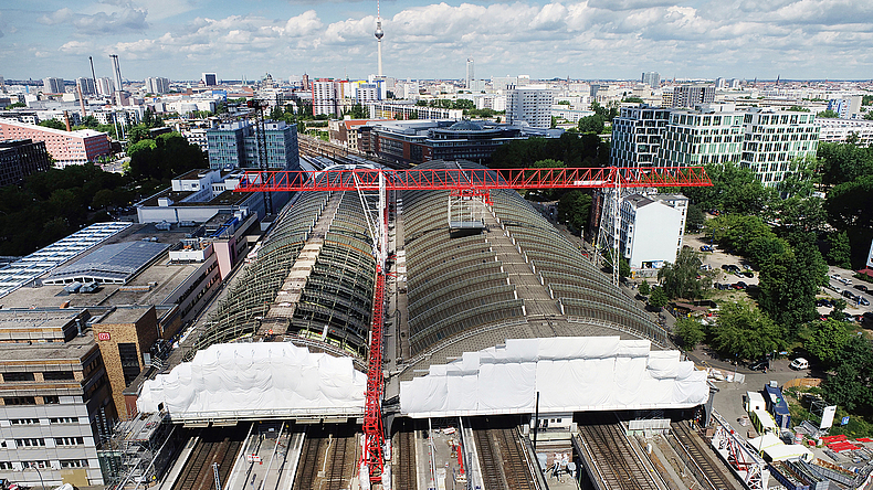 Drohnenaufnahme vom Ostbahnhof als Baustelle mit Schutzbrücke inmitten der umliegenden Gebäude.