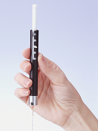 Nahaufnahme einer Hand, die einen spritzenförmigen Probebehälter hält.