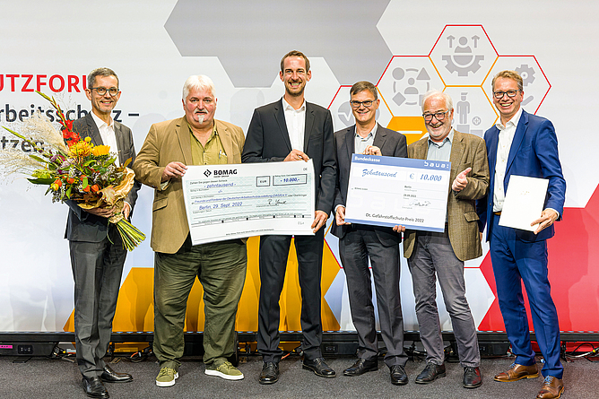 V. l. n. r.: Thomas von der Heyden (Institut für Arbeitsschutz der DGUV), Silvester Siegmann (Vorstand und Geschäftsführer der Freunde und Förderer der DASA), Felix Franzen (Bomag GmbH), Dipl.-Ing. Rafael Schomaker (Bomag GmbH), Harald Gröner (Vorsitzender der Freunde und Förderer der DASA), Peer-Oliver Villwock (BMAS)