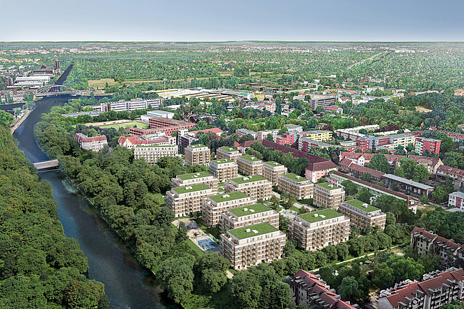 Luftaufnahme eines Wohnquartiers mit mehreren Mehrfamilienhäusern mit begrünten Dächern, umgeben von Bäumen und einem Fluss