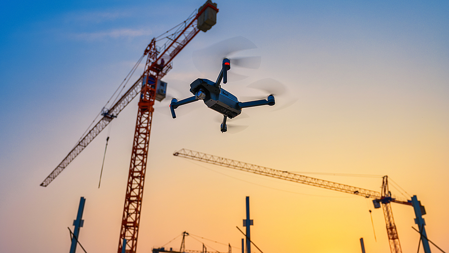 Eine Drohne fliegt über einer Baustelle.