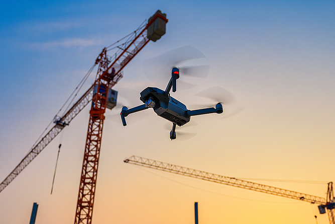 Eine Drohne fliegt über einer Baustelle.
