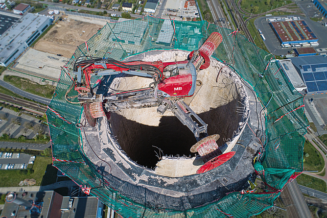 Der Schornsteinabbruch erfolgt mittels Drivebreakers im Schutze eines Schornsteinkonsolgerüsts.