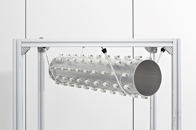 Gestell, in dem ein Rohr mit noppenartigen Resonatoren hängt.