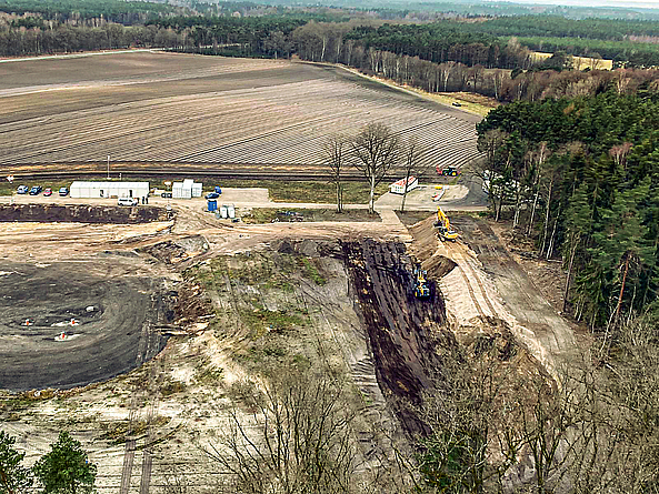 Kieselgur-Grube von oben, daneben sind Felder und ein Waldgebiet zu sehen.