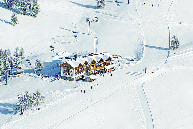 Das Hotel zur Jahrtausendwende Luftaufnahme eines Gebäudekomplexes inmitten einer schneebedeckten Landschaft.