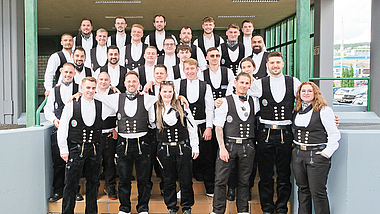 Gruppenbild der neuen Meisterinnen und Meister im Dachdecker- und Klempnerhandwerk, gekleidet in Zunftkleidung.