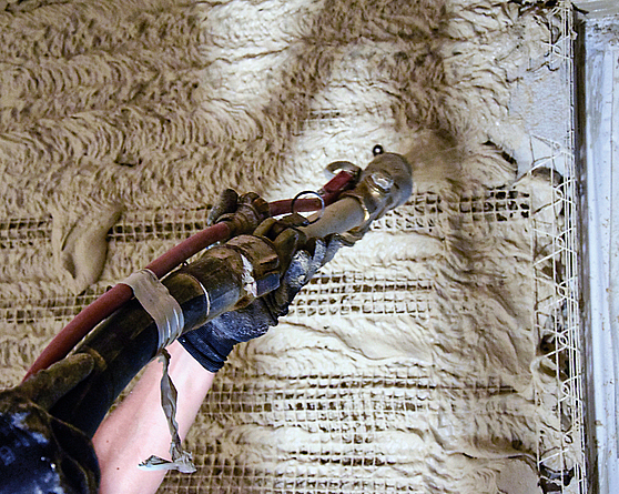 Bauarbeiten zur energetischen Sanierung der Innenbereiche: Verarbeitung der spritzbaren Dämmung.