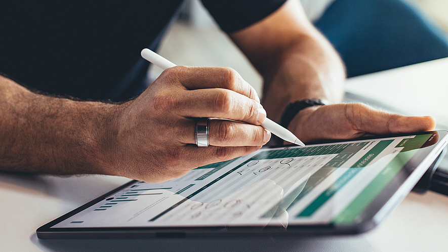 Mann arbeitet am Tablet.