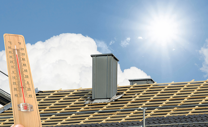 Ein Thermometer wird symbolisch vor ein Dach gehalten. Es zeigt eine Temperatur von über 37° Grad. Die Sonne scheint am Himmel, der teils mit Wolken bedeckt ist.