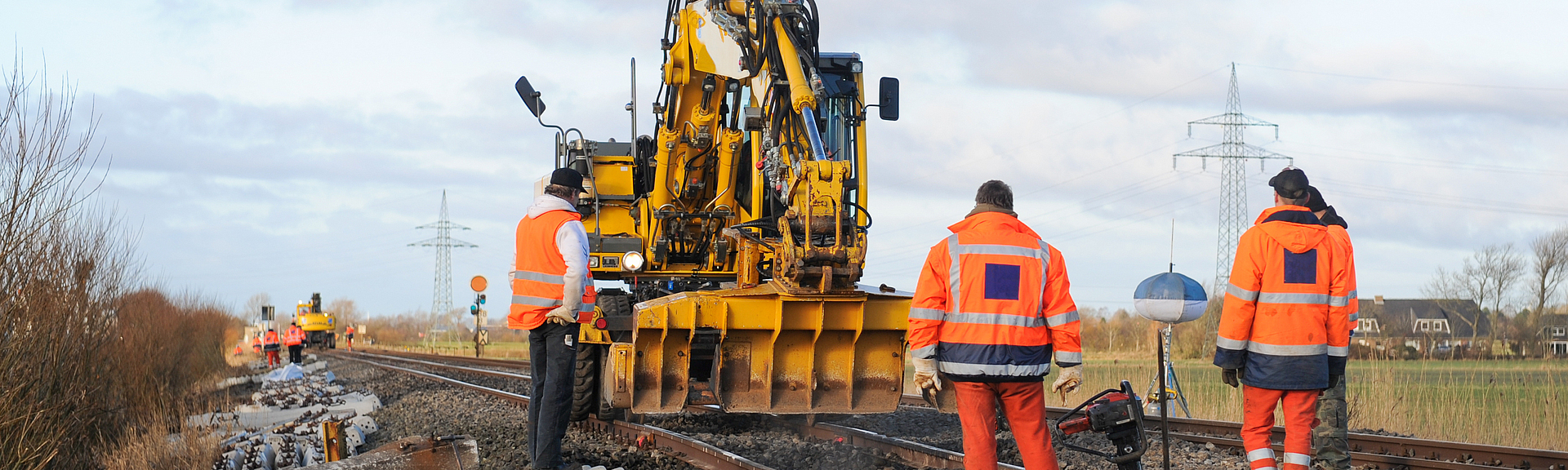Mehrere Bauarbeiter arbeiten an einem Bahngleis. 