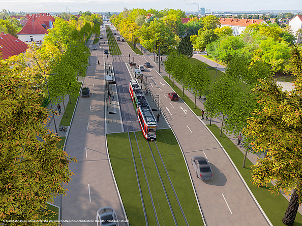 Luftaufnahme einer Straßenbahn, die durch eine Stadt fährt. Beidseitig Straßen, Häuser und viele Bäume. Der Gleisbereich ist begrünt.