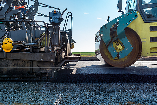 Am Ende einer Arbeitsschicht ist die fertige Asphalttragschicht zu sehen.