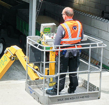 Bild von oben auf eine Bürste, die an einem Ausleger befestigt ist und auf einem Dach die Photovoltaik-Module säubert.