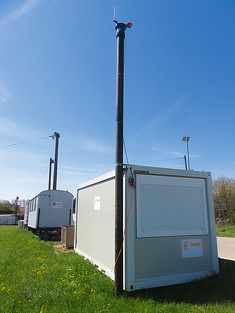 Wichtig für das Arbeiten mit BIM ist Funkkontakt. Hier die Basis- Station mit GPS-Antenne. Graue Container mit GPS-Antenne an einer Straße.