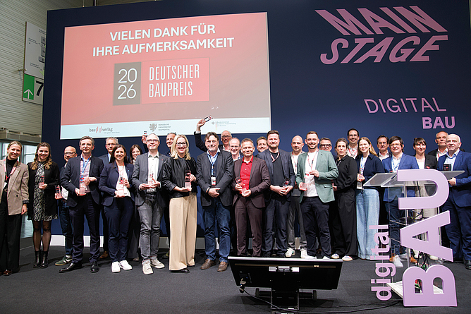Gruppe von Menschen steht auf einer Bühne und hält Auszeichnungen; im Hintergrund eine Präsentationswand mit der Aufschrift „DIGITAL BAU“.