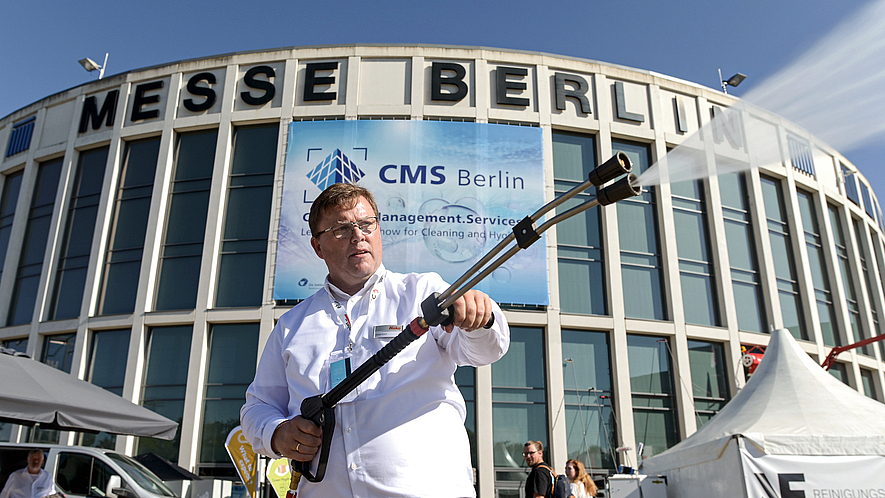 Mann führt während der CMS Berlin den Einsatz von Wasserdruckstrahlern vor dem Gebäude der Messe Berlin vor.