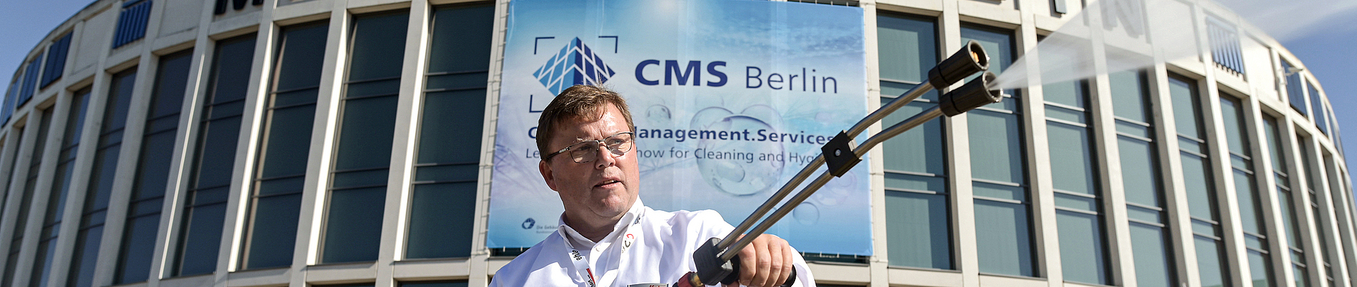 Mann führt während der CMS Berlin den Einsatz von Wasserdruckstrahlern vor dem Gebäude der Messe Berlin vor.