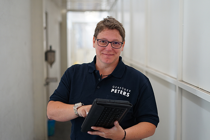 Porträt Julia Amler mit einer Mappe in der Hand.