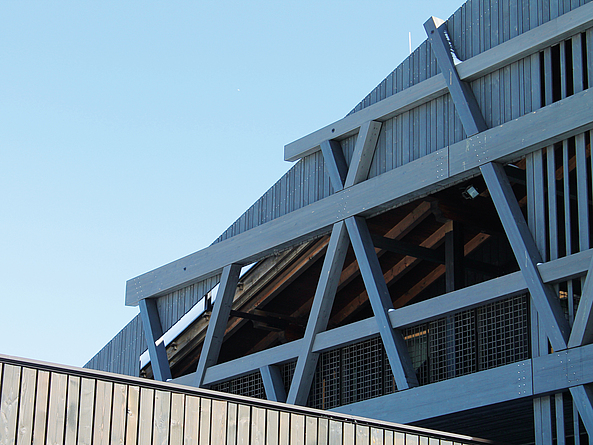 Fassadenkonstruktionin Lärchen-Brettschichtholz in Form eines Gitters aus verstärkenden schrägenStreben und horizontalen Riegeln.