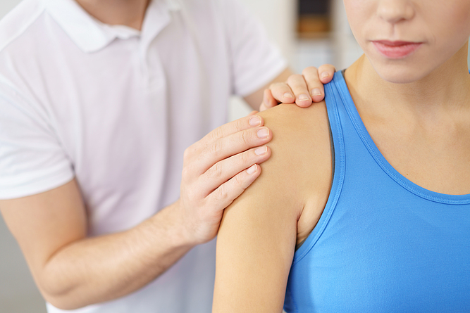 Eine Physiotherapeutin behandelt eine Patientin an der Schulter.