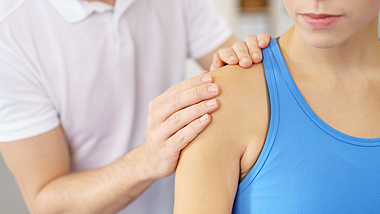 Eine Physiotherapeutin behandelt eine Patientin an der Schulter.