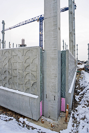 Betonfassadenelemente werden jeweils an eine Seite einer Stütze montiert. 