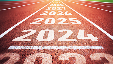 Jahreswechsel und Jahresplanungen Auf einer Kunststoffbahn (Tartanbahn) stehen die Zahlen 2023, 2024, 2025, 2026, 2027, 2028 und 2029.