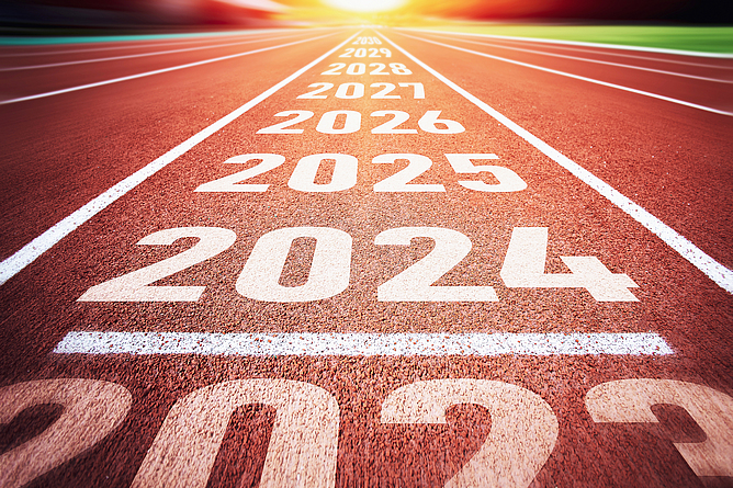 Auf einer Kunststoffbahn (Tartanbahn) stehen die Zahlen 2023, 2024, 2025, 2026, 2027, 2028 und 2029.