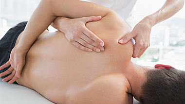 Physiotherapie Ein Patient ist bei der Physiotherapie und lässt seine Schulterschmerzen behandeln.