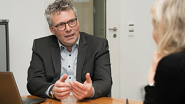 Markus Wanck im Interview mit BauPortal, sitzend an einem Tisch im Büro.