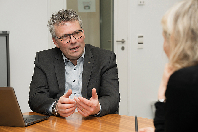 Markus Wanck im Interview mit BauPortal, sitzend an einem Tisch im Büro.