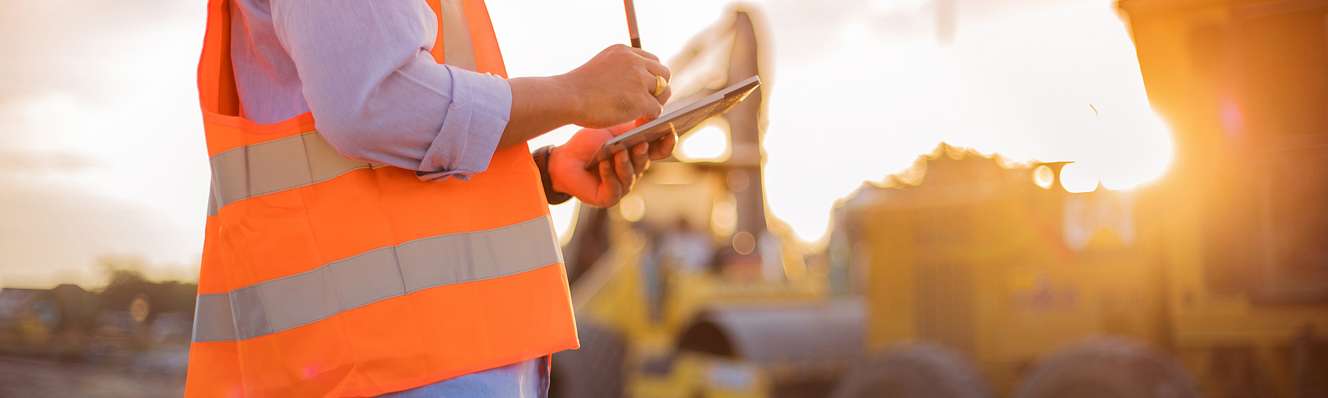 Ein Bauarbeiter benutzt ein Tablet auf einer Baustelle.